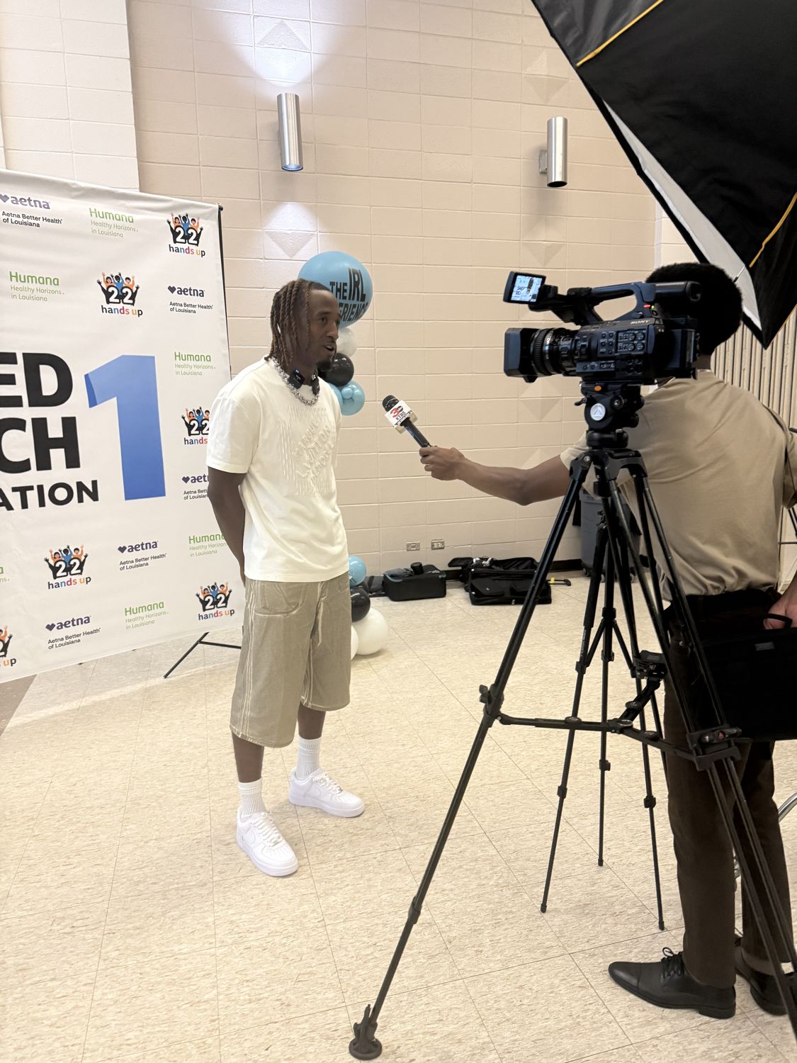 An athlete interviewed by local TV at a community event